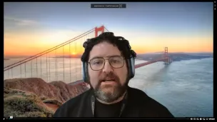 Man with beard in front of Golden Gate Bridge photograph.
