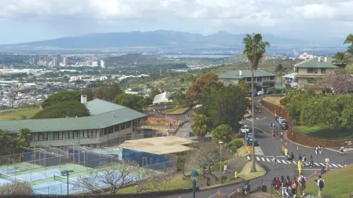 Landscape view of a building in Hawaii, with mountains in the distance.