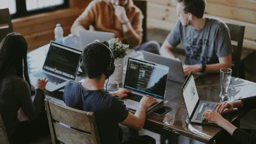 People sitting around a table working on laptops.