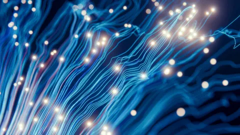 Blue, glowing light trails with white spheres, photograph.