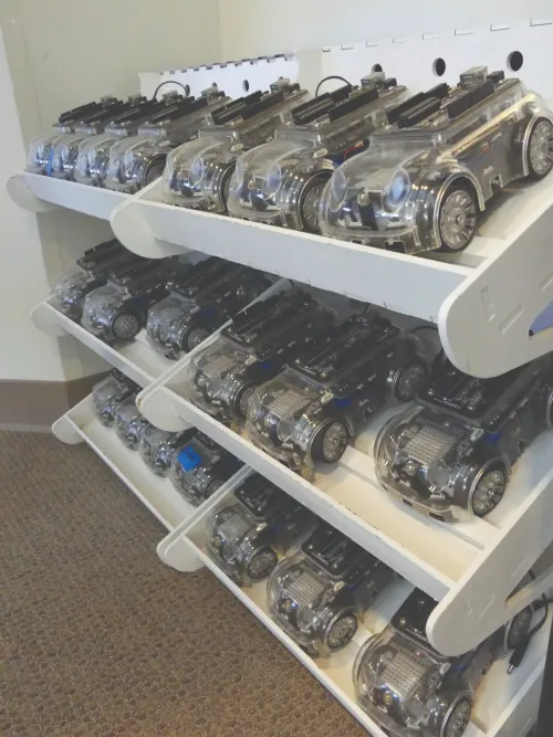 Shelves holding rows of robotic cars.